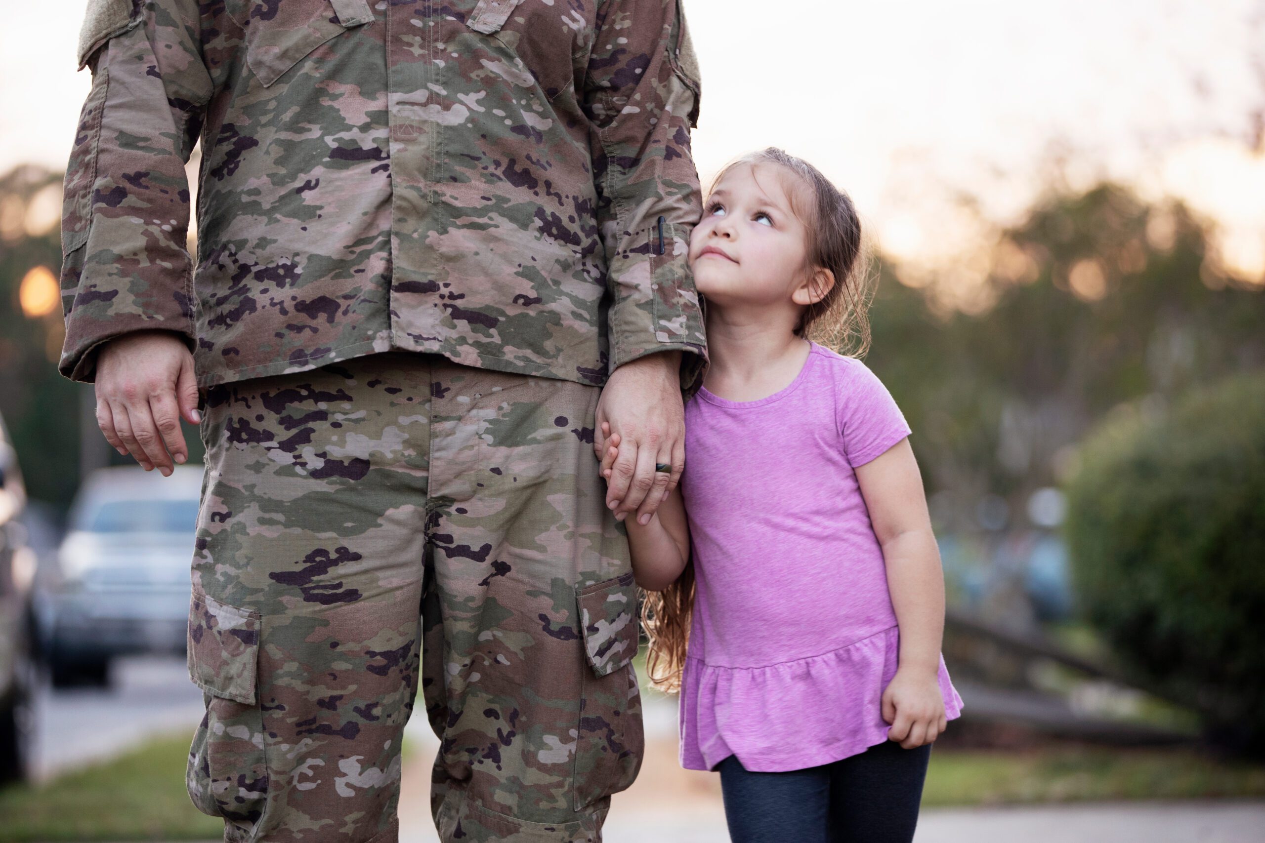 Young girl holding her father's hand